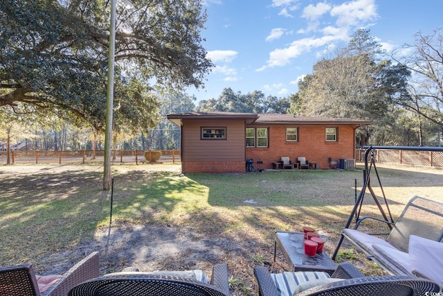 back of house with cooling unit and a yard