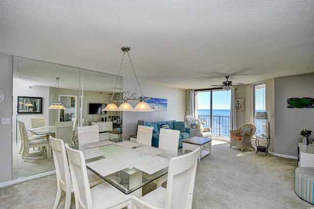 dining room with ceiling fan, expansive windows, carpet floors, and a textured ceiling