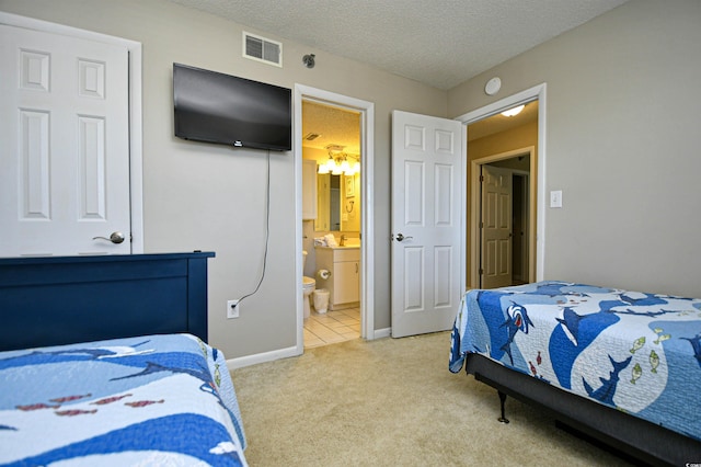 bedroom featuring light carpet, a textured ceiling, and connected bathroom