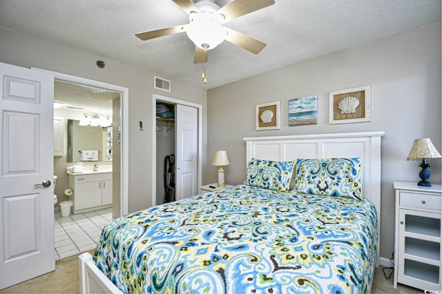 bedroom with ensuite bath, ceiling fan, sink, a textured ceiling, and a closet