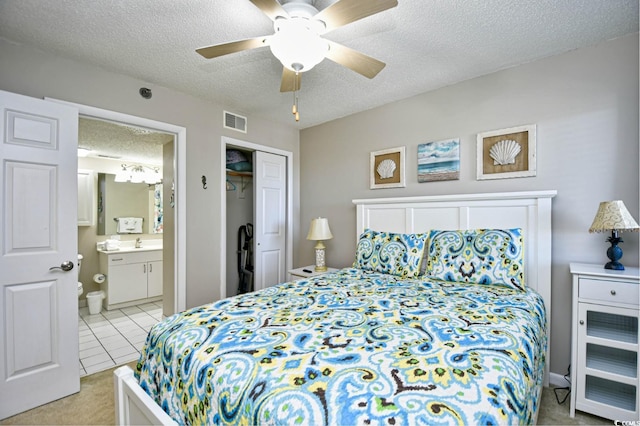 3601 S Ocean Blvd Unit 7-E, North Myrtle Beach, SC 29582 - bedroom with a textured ceiling, a closet, connected bathroom, a ceiling fan, and light tile patterned floors