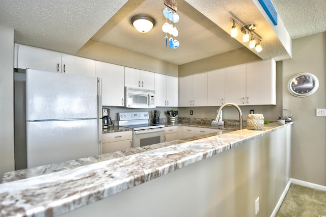 kitchen featuring white cabinets, light stone counters, white appliances, and sink