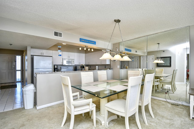 carpeted dining area with a textured ceiling