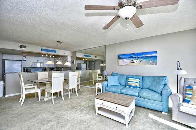 living room featuring light carpet, a textured ceiling, and ceiling fan