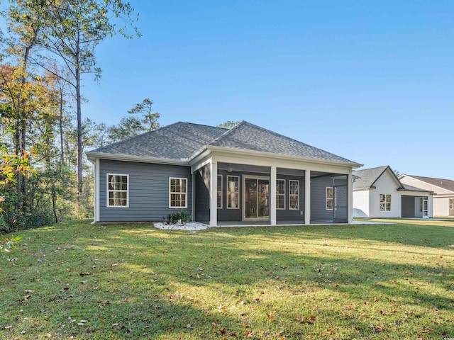 rear view of property with a sunroom and a yard