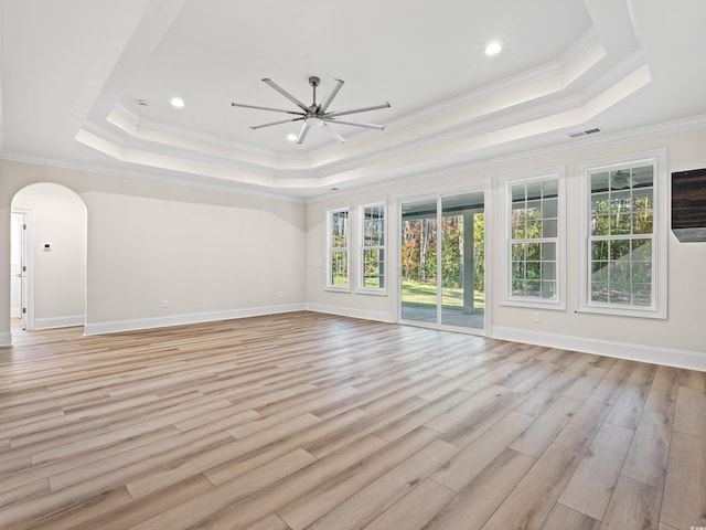 interior space with ceiling fan, light hardwood / wood-style flooring, crown molding, and a tray ceiling