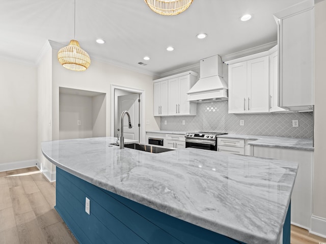 kitchen with white cabinets, light stone countertops, custom range hood, and hanging light fixtures