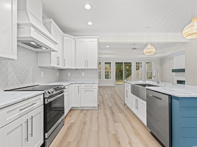 kitchen with white cabinets, custom exhaust hood, stainless steel appliances, and decorative light fixtures