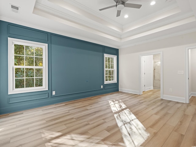 unfurnished room with ceiling fan, ornamental molding, light hardwood / wood-style flooring, and a tray ceiling