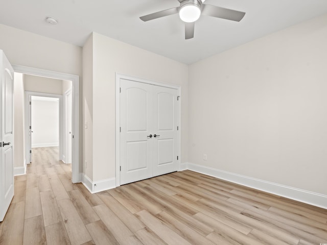 unfurnished bedroom featuring ceiling fan, light wood-type flooring, and a closet