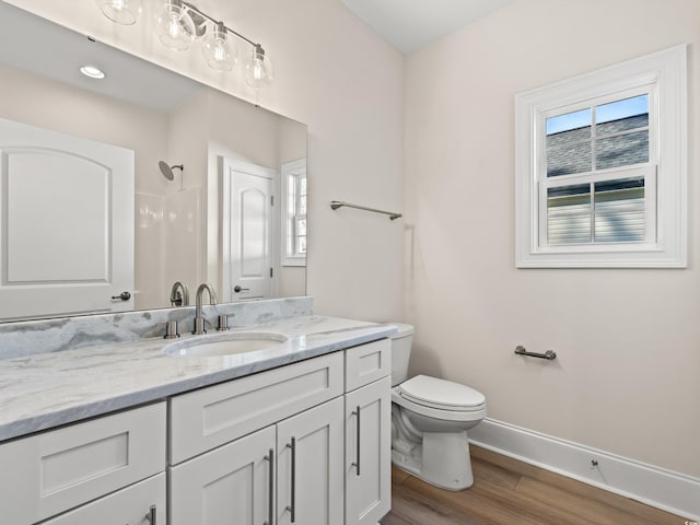 bathroom featuring walk in shower, vanity, wood-type flooring, and toilet