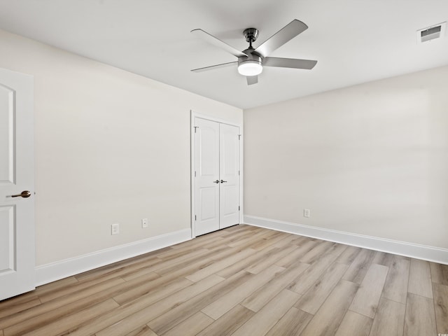 unfurnished bedroom featuring ceiling fan, a closet, and light hardwood / wood-style floors