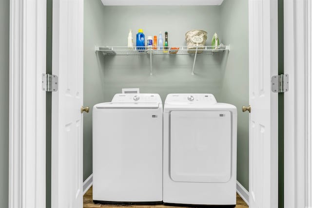 clothes washing area with hardwood / wood-style floors and washing machine and clothes dryer