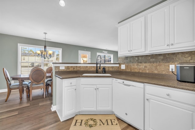 kitchen featuring white dishwasher, sink, and white cabinets