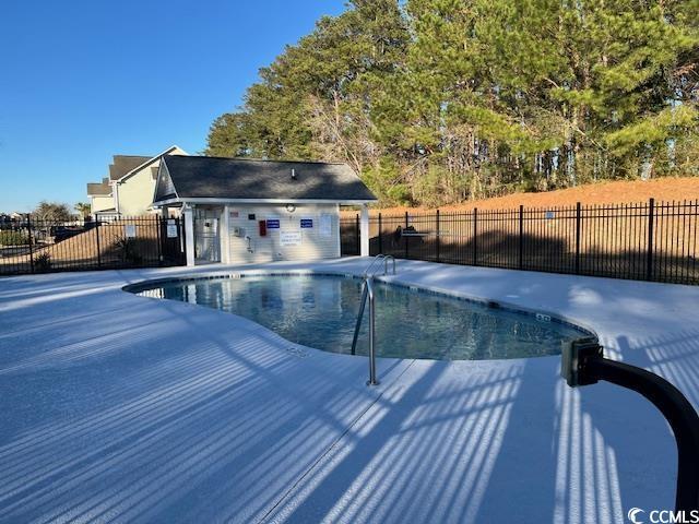 view of swimming pool featuring a patio and an outdoor structure