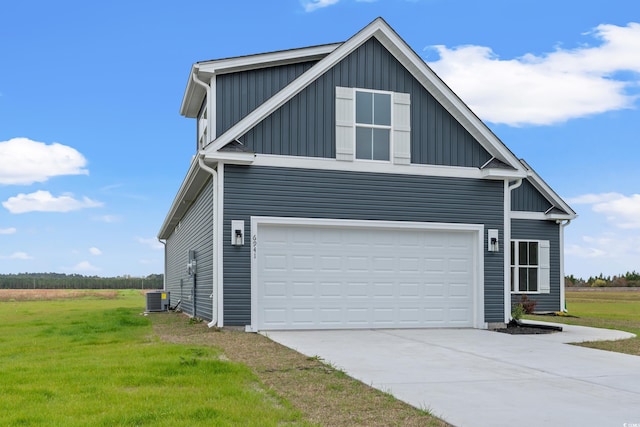 view of side of property featuring a yard, a garage, and central air condition unit