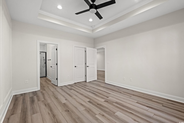 unfurnished bedroom with ceiling fan, a raised ceiling, light hardwood / wood-style flooring, stainless steel fridge, and ornamental molding