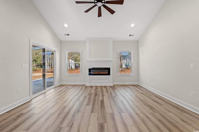 unfurnished living room with light hardwood / wood-style floors, ceiling fan, and lofted ceiling