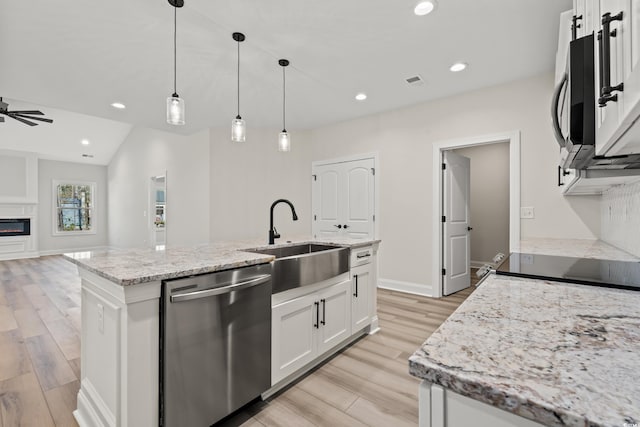 kitchen featuring white cabinetry, dishwasher, ceiling fan, sink, and a kitchen island with sink