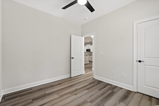 unfurnished bedroom featuring wood-type flooring and ceiling fan