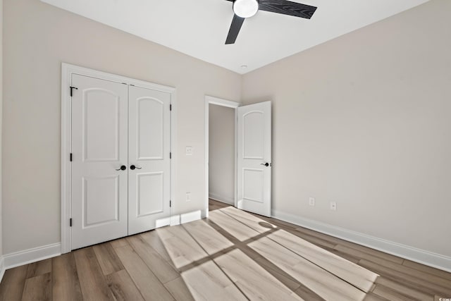 unfurnished bedroom featuring hardwood / wood-style flooring, ceiling fan, and a closet