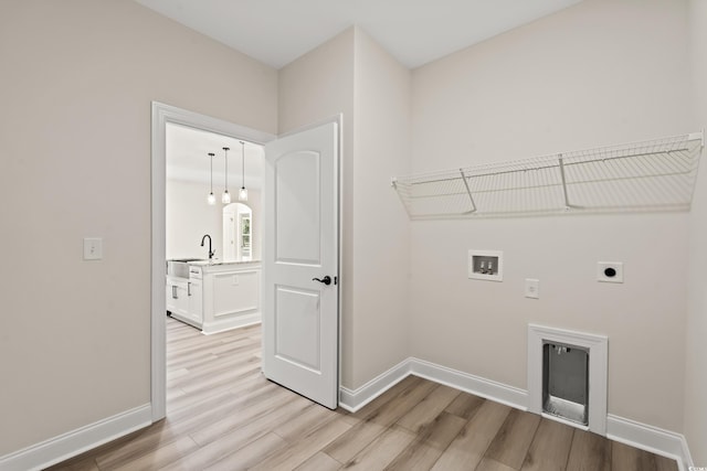 laundry room featuring washer hookup, light hardwood / wood-style floors, electric dryer hookup, and sink