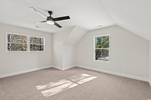 additional living space with light colored carpet, vaulted ceiling, and ceiling fan