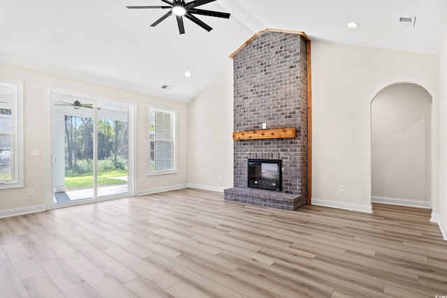 unfurnished living room with light hardwood / wood-style flooring, a brick fireplace, and lofted ceiling