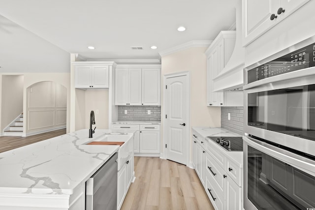 kitchen with light stone countertops, white cabinets, and appliances with stainless steel finishes