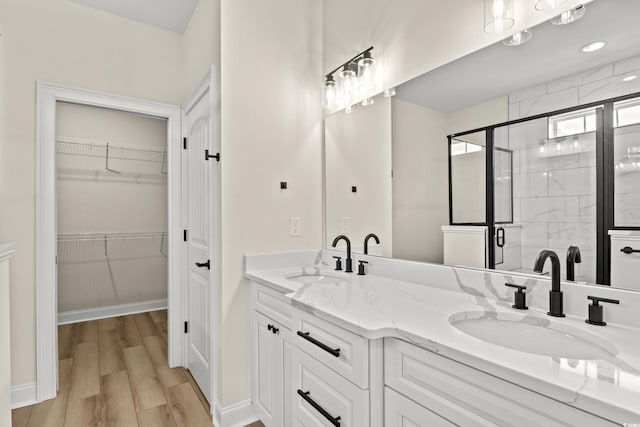 bathroom featuring hardwood / wood-style floors, vanity, and a shower with door