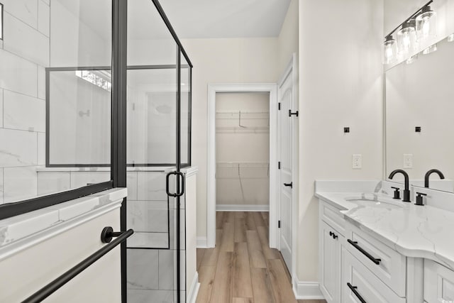 bathroom featuring hardwood / wood-style flooring, vanity, and a shower with door