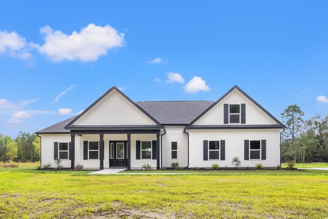 modern farmhouse with covered porch and a front yard