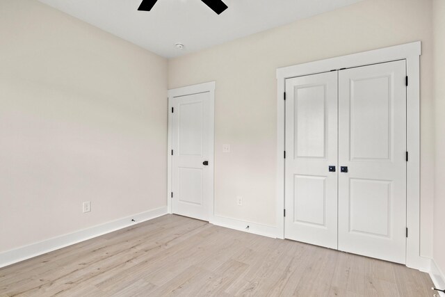 unfurnished bedroom with ceiling fan, light hardwood / wood-style floors, and a closet