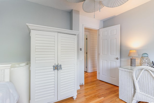 bedroom with ceiling fan, a closet, and light wood-type flooring