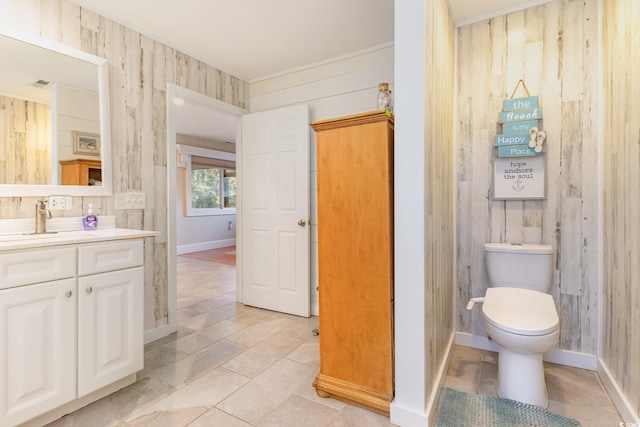 bathroom with tile patterned floors, wood walls, vanity, and toilet