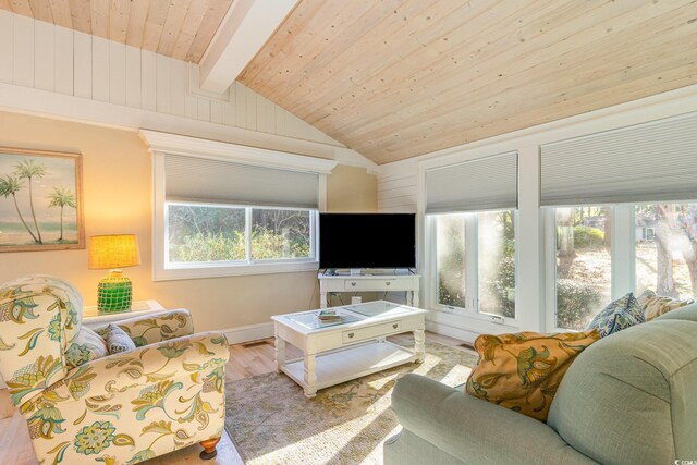 living room featuring a healthy amount of sunlight, lofted ceiling with beams, wood ceiling, and light wood-type flooring