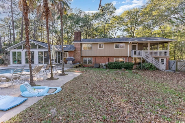 back of property with central AC unit, a patio area, and a sunroom