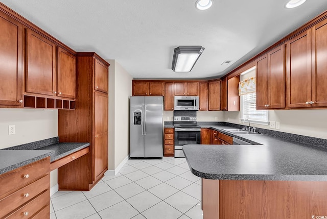 kitchen with light tile patterned floors, brown cabinetry, built in study area, dark countertops, and stainless steel appliances