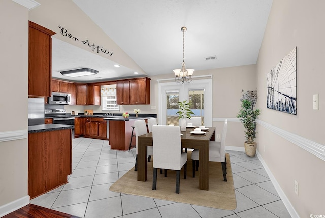 dining space with baseboards, visible vents, an inviting chandelier, vaulted ceiling, and light tile patterned flooring