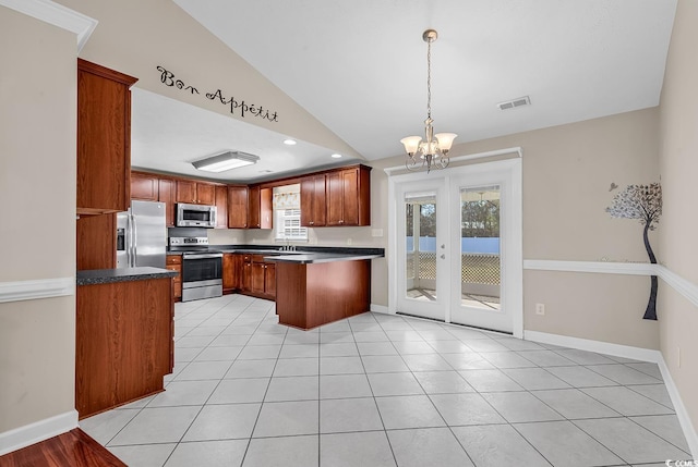 kitchen featuring appliances with stainless steel finishes, dark countertops, visible vents, and a peninsula