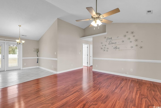 empty room with lofted ceiling, visible vents, baseboards, and wood finished floors