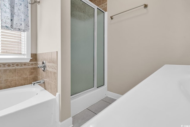 bathroom featuring a tub, tile patterned flooring, and a shower with shower door