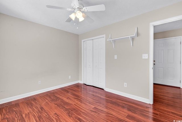 unfurnished bedroom featuring a ceiling fan, a closet, baseboards, and wood finished floors