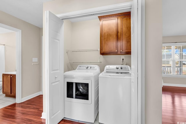 laundry area with wood finished floors, cabinet space, baseboards, and separate washer and dryer