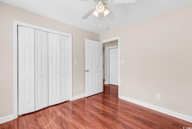 unfurnished bedroom with ceiling fan, a closet, wood finished floors, and baseboards