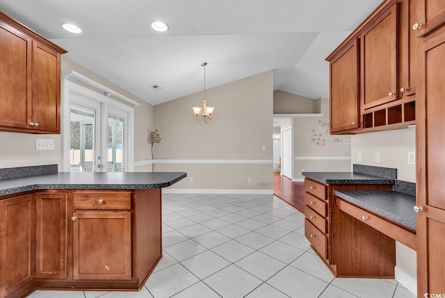 kitchen featuring lofted ceiling, dark countertops, light tile patterned flooring, and brown cabinets