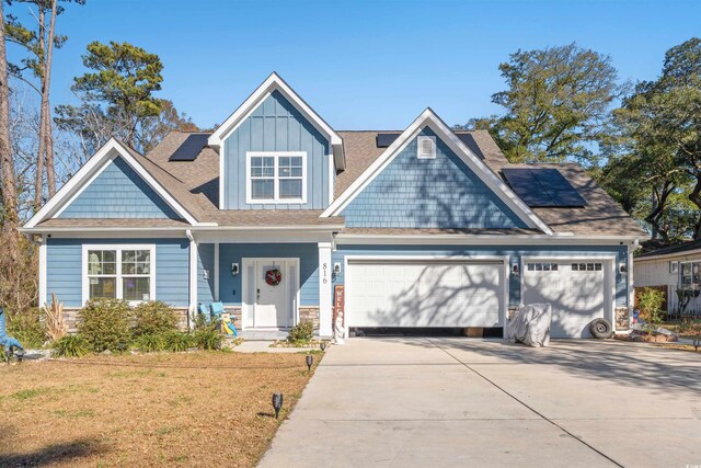 view of front of home featuring solar panels and a garage