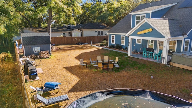 rear view of property featuring a storage shed and a patio