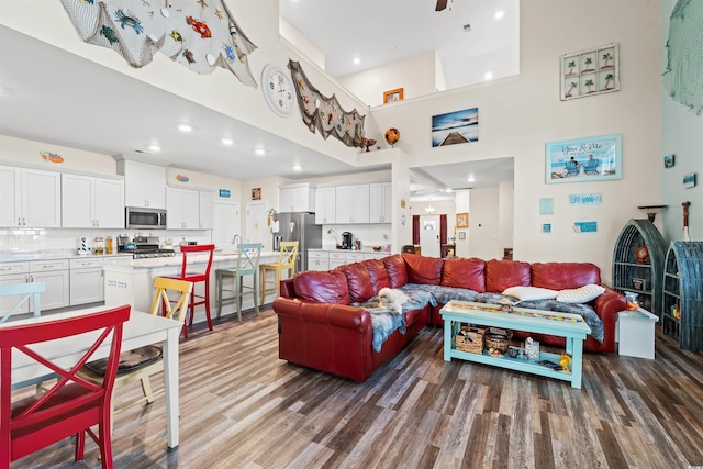 living room with hardwood / wood-style flooring and a towering ceiling