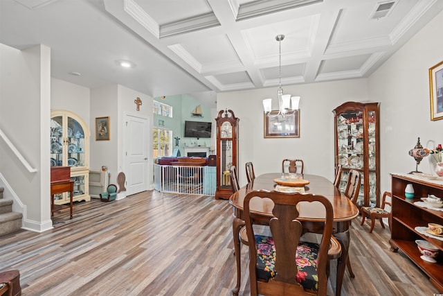 dining area with hardwood / wood-style flooring, beam ceiling, a chandelier, and coffered ceiling